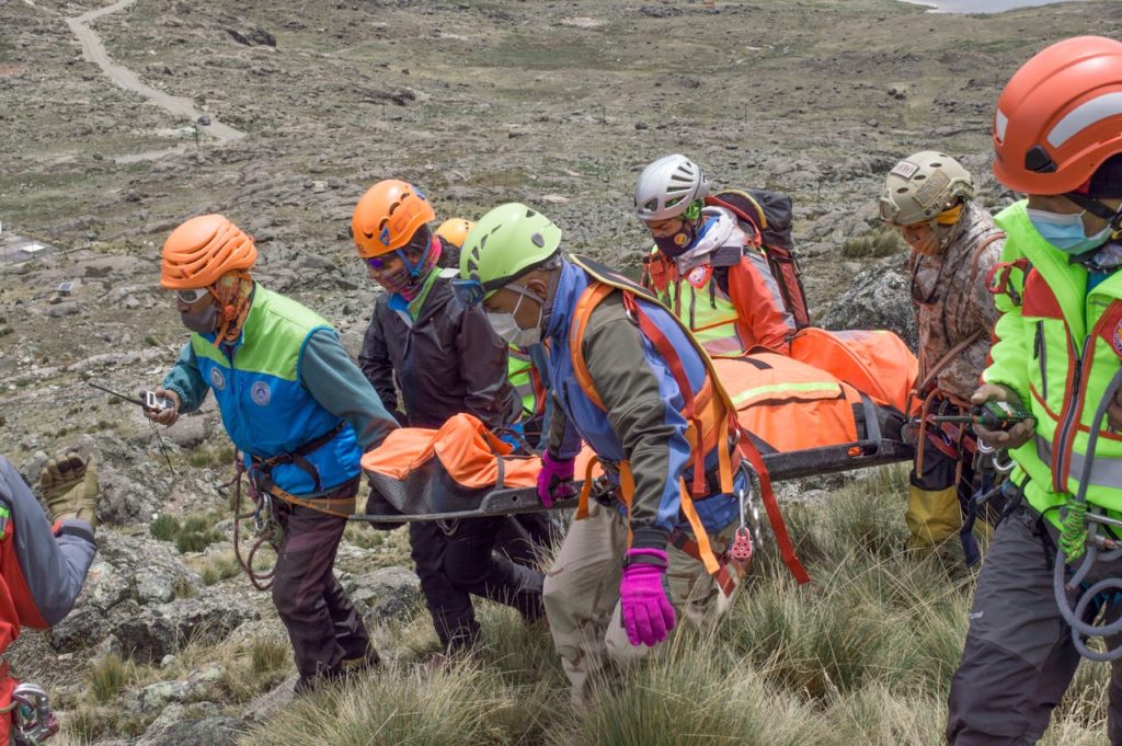 Rescue team carrying patient on stretcher during a mountain rescue in La Paz, Bolivia.
